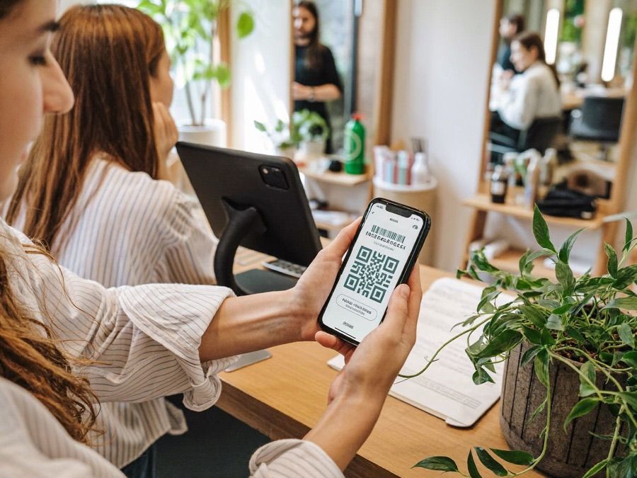 Friseurin scannt die Treuekarte einer Kundin